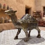 Artistic Camel Ashtray with Antique Finish and Intricate Carvings on a White Table