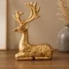 Golden sitting deer figurine with floral design for tabletop home decor