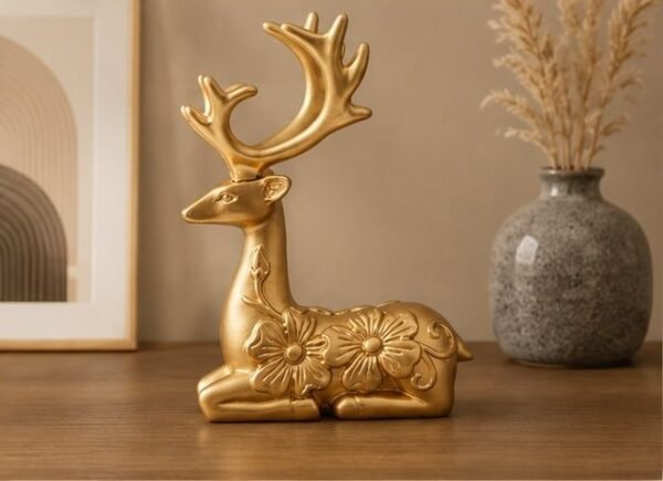 Golden sitting deer figurine with floral design for tabletop home decor